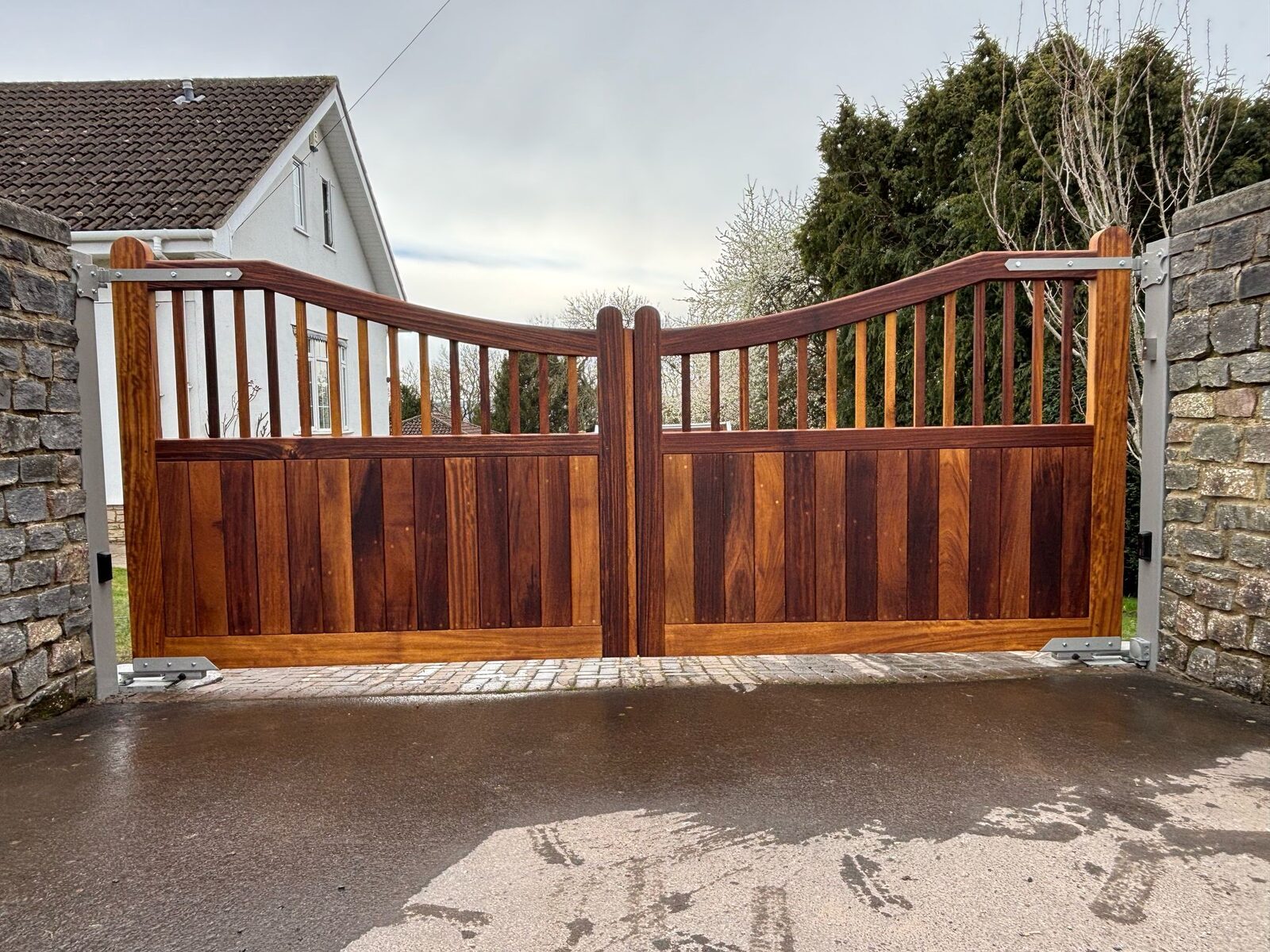 Hardwood driveway gates with picket top infill set between stone walls